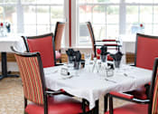 Thumbnail 3 of 5 - a dining room table with red chairs and windows with red curtains