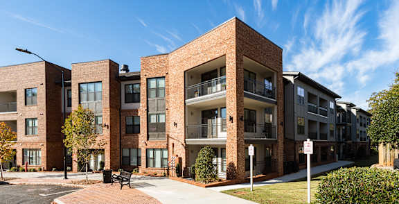 A modern brick apartment building with a clear blue sky above.