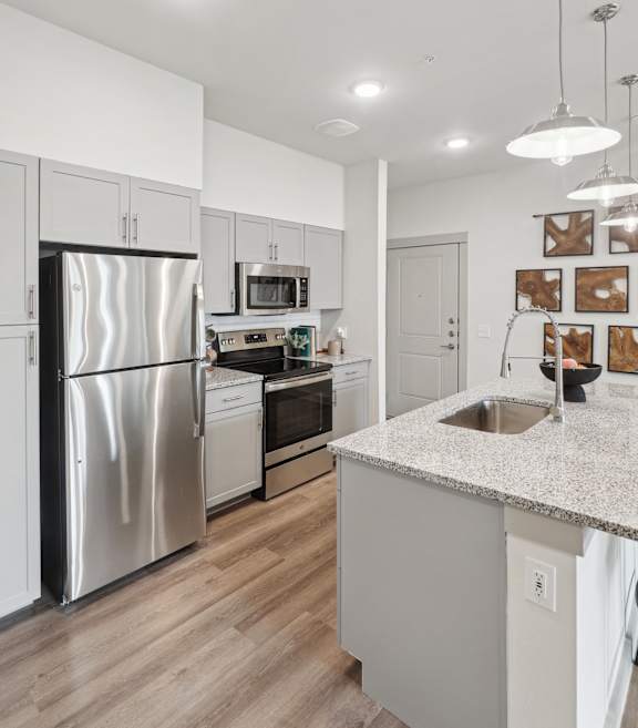 Modern apartment kitchen with stainless steel appliances, quartz countertops, and designer cabinetry at The Westerly Apartments in Midlothian, TX