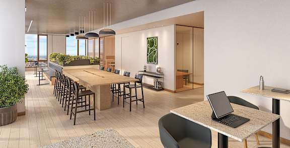 A modern office space with a long table, chairs, and a laptop on a table.