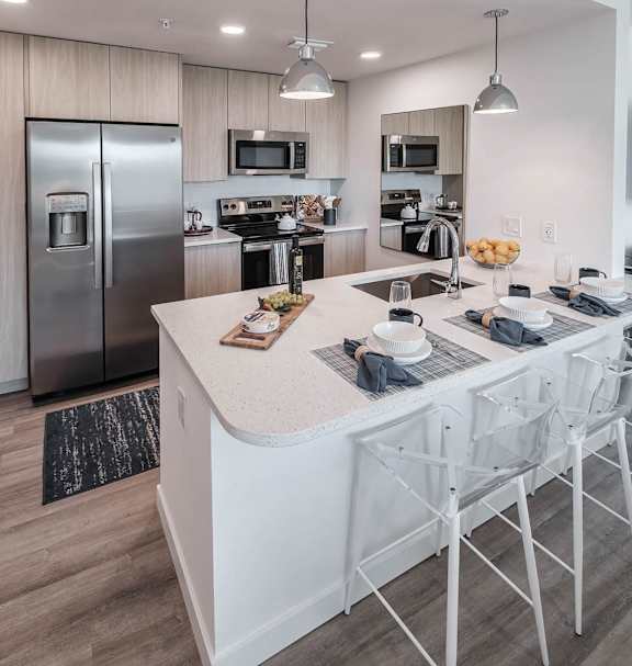 a kitchen with a large island and stainless steel appliances  Altis Santa Barbara, Naples, FL