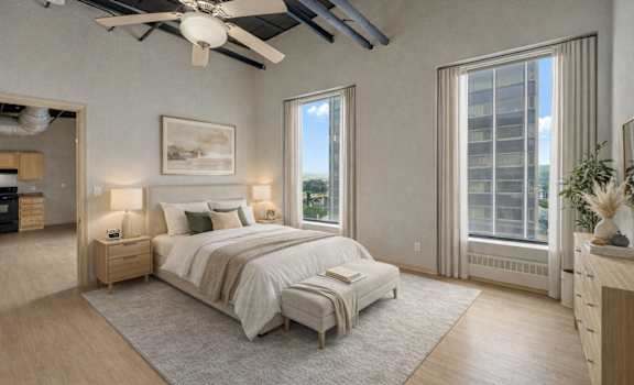 A bedroom with a large bed and a ceiling fan.