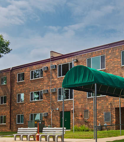a large brick building with a green canopy in front of it