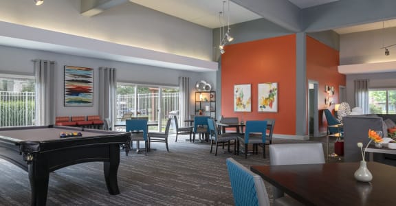 a clubhouse with a pool table and a dining room with chairs and tables