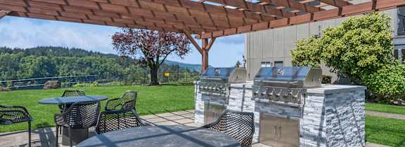 A patio with a table and chairs under a wooden pergola.