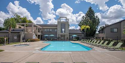Autumn Oaks apartments pool, spa, lounge chairs and clubhouse building at Autumn Oaks Apartments, Roseville, California