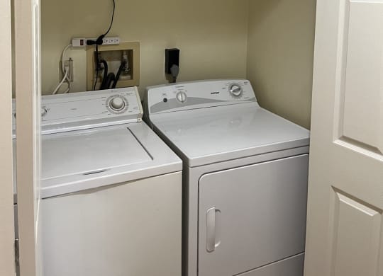 a laundry room with two washers and a dryer at Monroeville Apartments, Monroeville, PA
