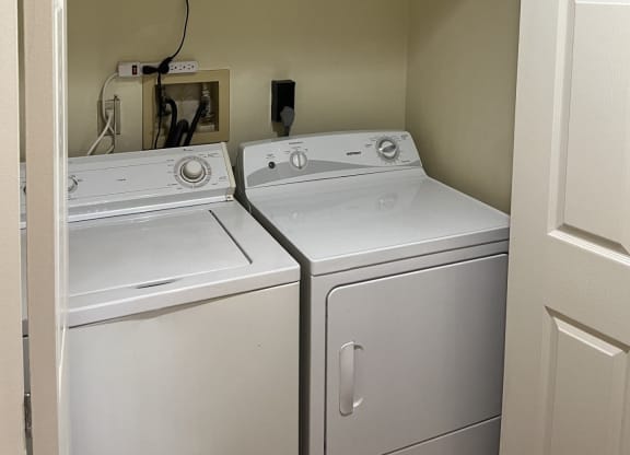 a laundry room with two washers and a dryer at Monroeville Apartments, Monroeville, PA