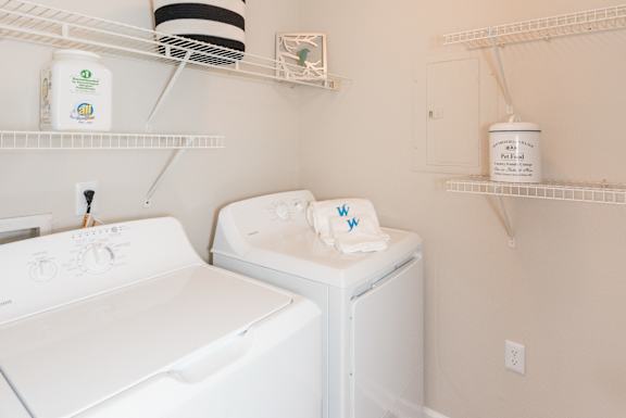 A white washing machine and dryer in a small laundry room. at WildForest Apartments, Birmingham, AL, 35209