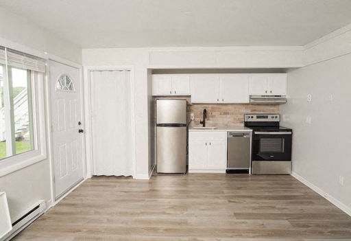 A kitchen with white cabinets and stainless steel appliances.