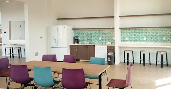 A kitchen with a table and chairs in front of a counter.