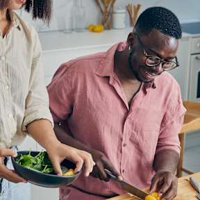 A man and woman are preparing a salad together at The Glover House Apartments, Washington, DC
