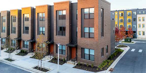 an aerial view of a brick apartment building with a parking lot