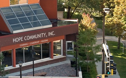 A building with a solar panel on the roof and the words "Hope Community, Inc." on the front.