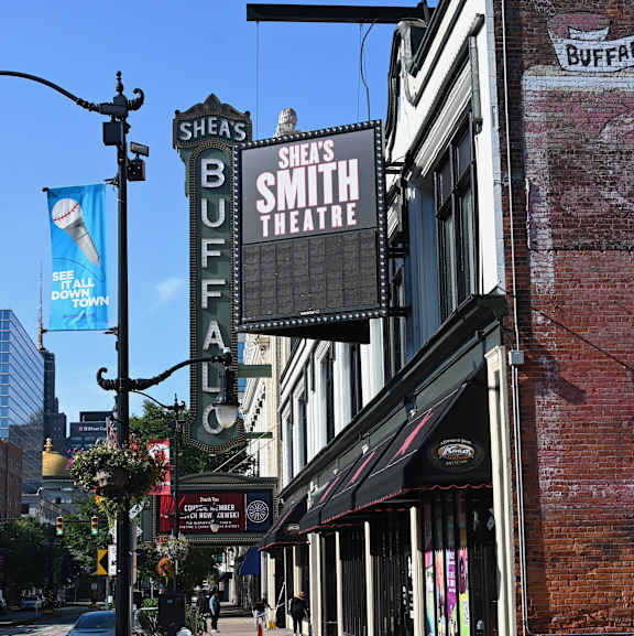 A street view of a city with a sign for Shea's Smith Buffalo Theatre.