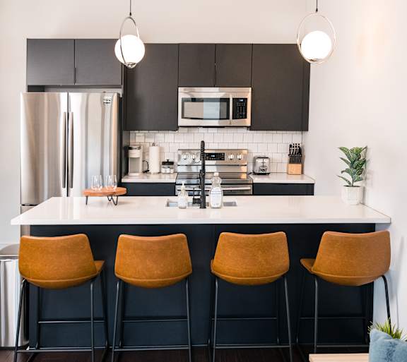 A modern kitchen with a black countertop and a sink with a red object in it.