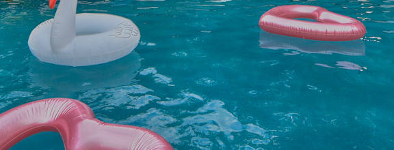 a swimming pool with chairs in front of a house at The Quarry Alamo Heights Apartments, Texas, 78209