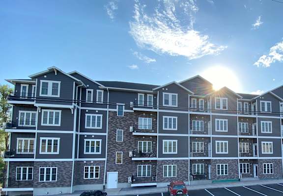 a rendering of an apartment building in a parking lot