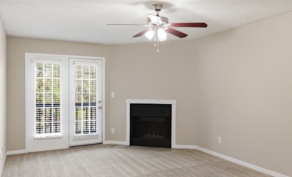 A room with a fireplace and a ceiling fan.