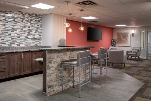 a lobby with a bar and chairs and a television