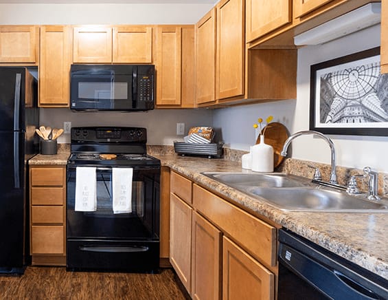 a kitchen with black appliances and wooden cabinets