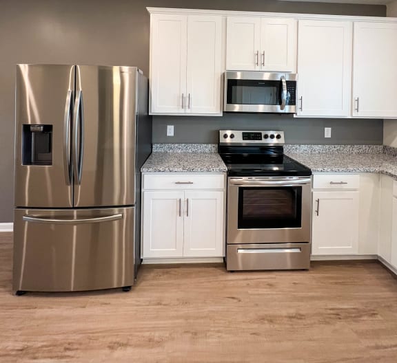 a kitchen with stainless steel appliances and white cabinets