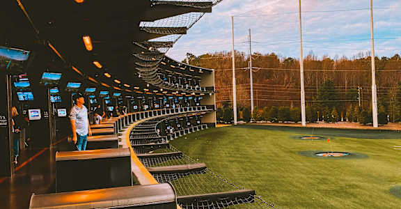a person standing playing golf at topgolf