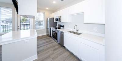 a kitchen with white cabinets and a white counter top at Tiffany Flats, Columbus