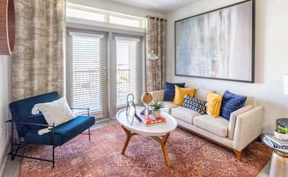 a living room with a white couch and a blue chair