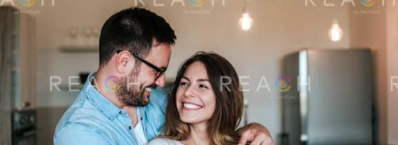 A man and woman hugging each other in a room.
