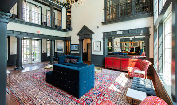 A large room with a blue couch and a chandelier. at Fairfax Square Apartments, Fairfax, VA, 22031