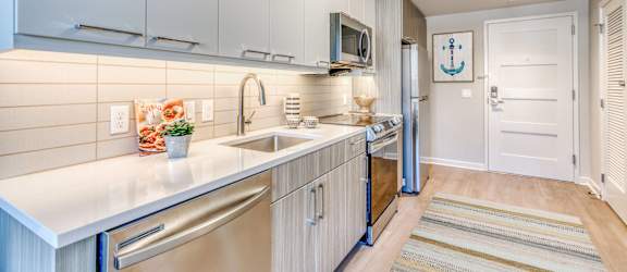 a large kitchen with stainless steel appliances and white cabinets