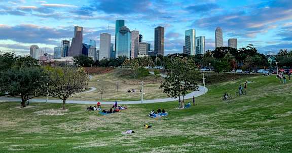 Four people walking together in a park.