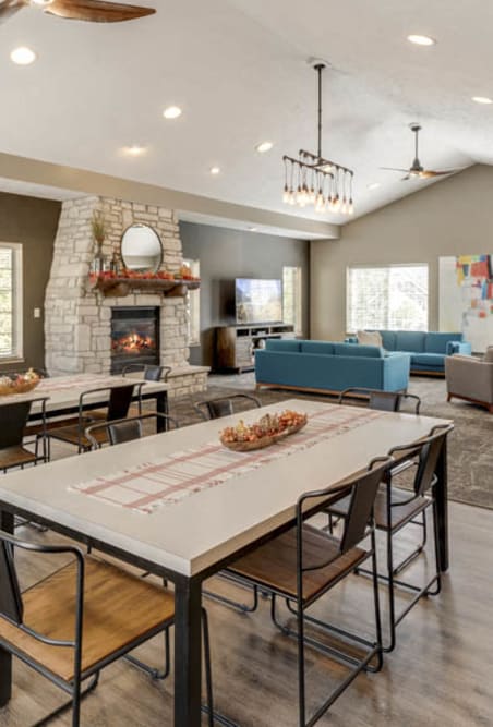 a gathering room with a table and chairs and a fireplace