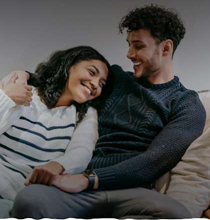 a man and woman sitting on a couch laughing