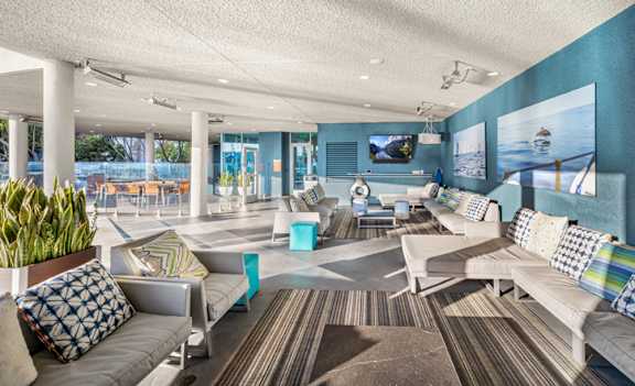 A living room with a couch, chairs, and a television. at Esprit Apartments, Marina del Rey, CA
