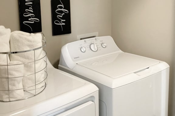a white washer and dryer in a laundry room with two black towels at The Shallowford, Tennessee