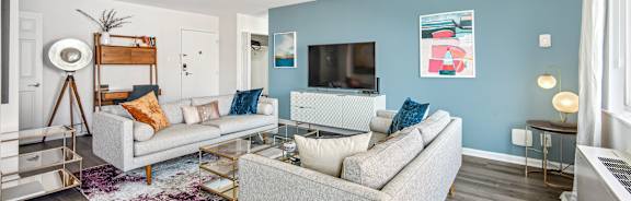 A living room with a grey couch and a white coffee table.