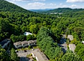 Thumbnail 18 of 21 - A bird's eye view of a residential area surrounded by a dense forest.