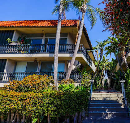 A building with a red roof and a balcony with a railing.