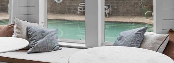 a screened in porch with tables and chairs and a pool