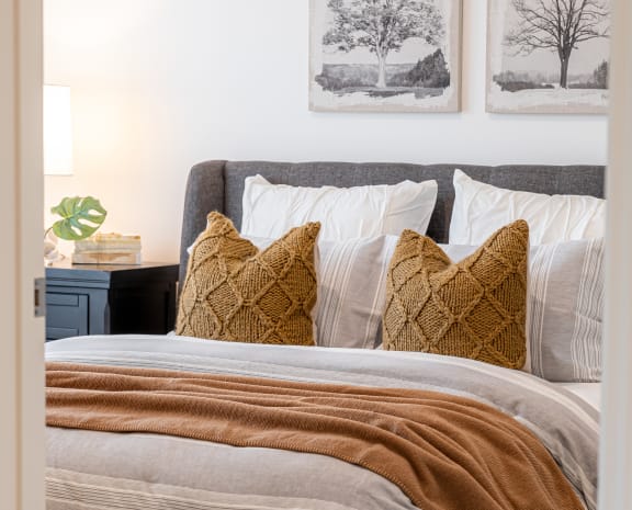 a bedroom with a bed and pillows and pictures on the wall
