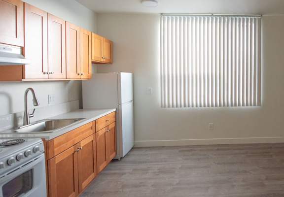 A kitchen with wooden cabinets and a white refrigerator.