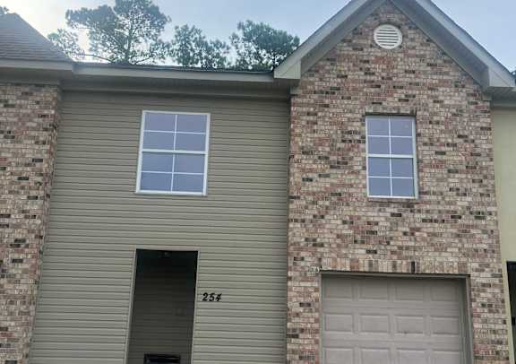 A house with a grey roof and a stone wall.