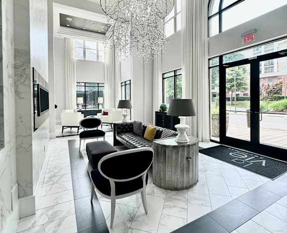 A black and white interior of a building with a chandelier hanging from the ceiling.