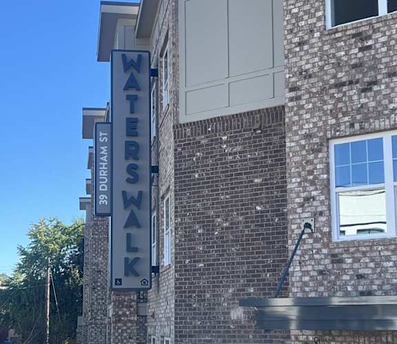 A sign on a building that says "Waters Walk".