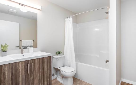 A white bathroom with a toilet, sink, and shower. at G17 Apartments at Tamarack, Alberta, T6T 2M4