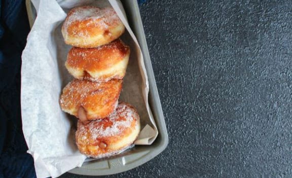 a box of donuts with powdered sugar on a table