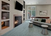 Thumbnail 17 of 21 - Living room at Ascent at Mallard Creek Apartment Homes. Carpet area with a fire place, tv, couch, pool table, tables, and big windows.