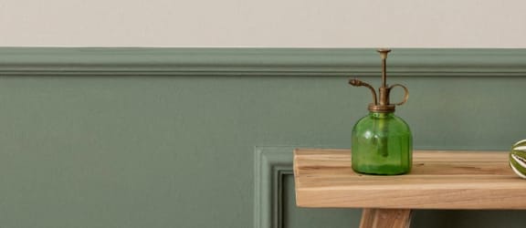 a white wall with a wooden table with plants on it